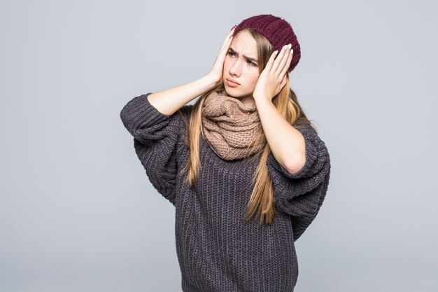 Modelo joven vestido de moda tiene dolor de cabeza y estómago en gris