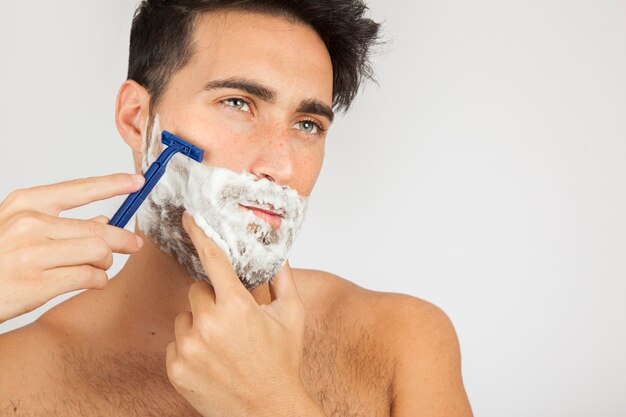 Modelo masculino afeitándose la barba