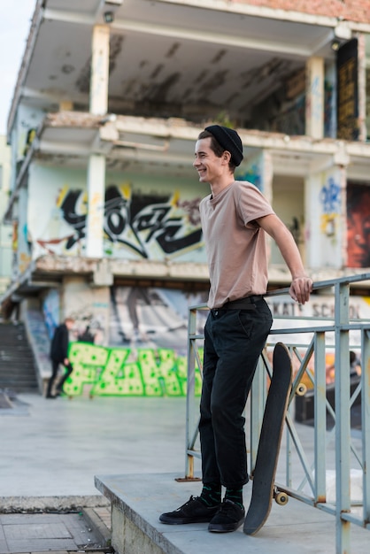 Modelo masculino joven posando con patineta