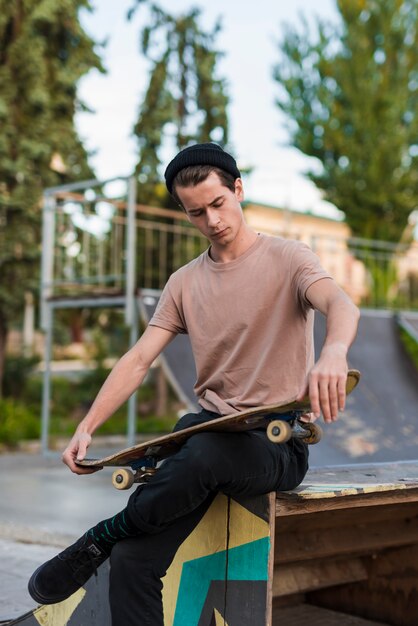 Modelo masculino joven posando con patineta