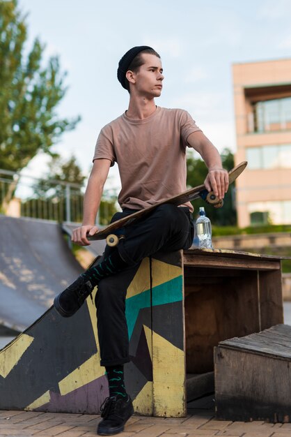 Modelo masculino joven posando con patineta