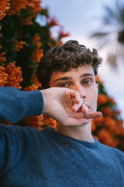 Modelo masculino posando con las manos cerca de la cara