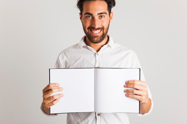 Modelo masculino sonriente posando con libro