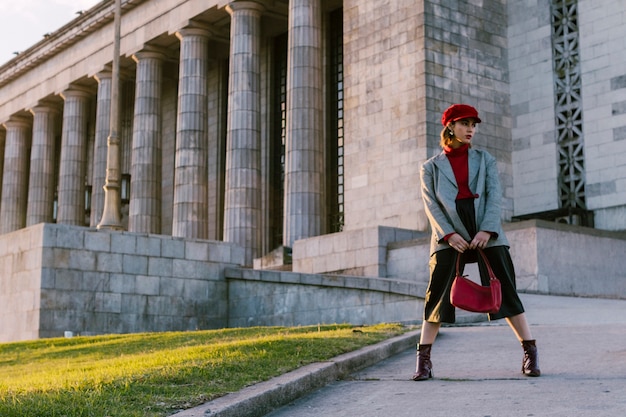 Modelo de moda de belleza mujer con elegante abrigo sosteniendo el bolso en la mano