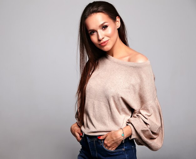 modelo morena en ropa casual suéter cálido beige sobre gris