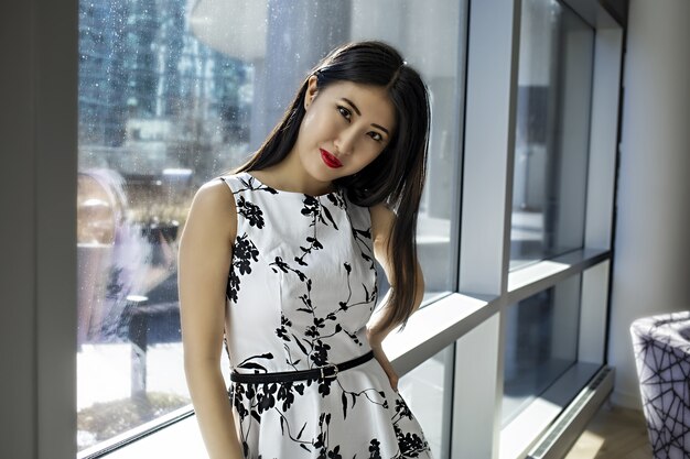 Modelo de mujer asiática lleva un vestido blanco sexy de moda