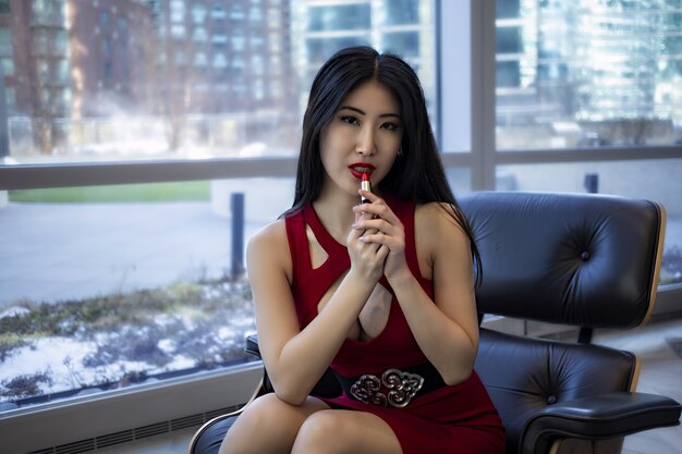 Modelo de mujer asiática lleva un vestido rojo sexy de moda