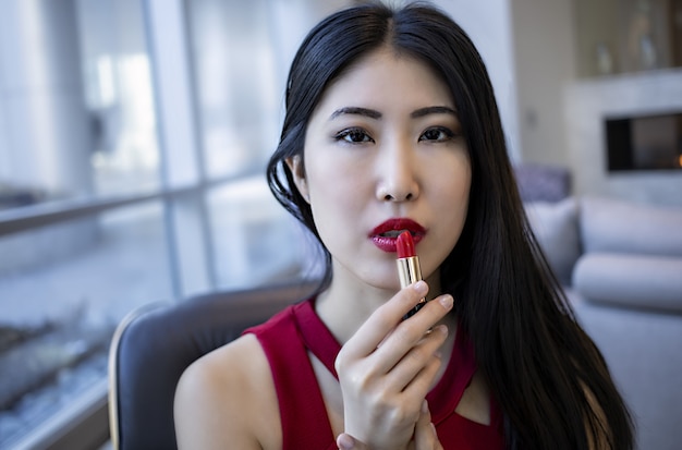 Modelo de mujer asiática lleva un vestido rojo sexy de moda