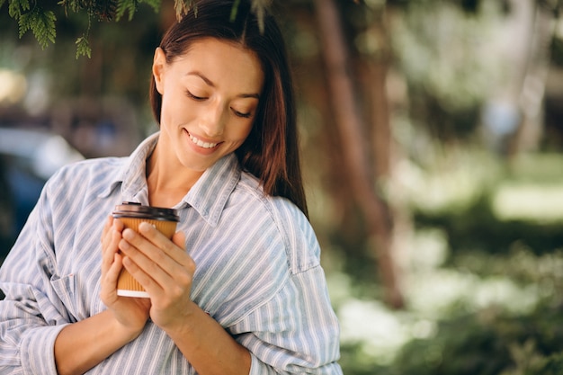 Modelo de mujer en camisa de hombre bebiendo café