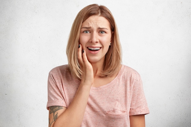 Modelo de mujer desesperada y triste tiene un problema en la vida, frunce el ceño con insatisfacción, va a llorar, necesita el apoyo de personas cercanas, tiene una apariencia atractiva