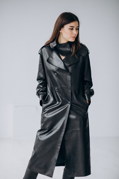 Modelo de mujer joven con abrigo largo de cuero negro