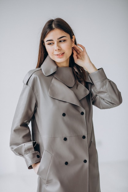 Foto gratuita modelo de mujer joven con abrigo largo gris