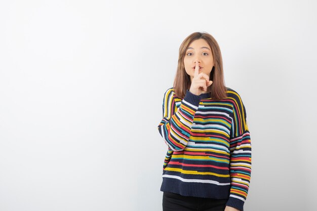 modelo de mujer joven y bonita que muestra el signo de silencio.