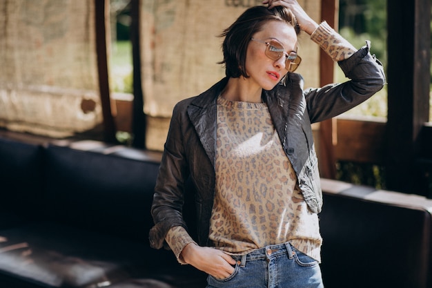 Modelo de mujer joven en chaqueta posando afuera