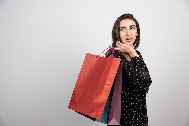 Modelo de mujer joven con un montón de bolsas de la compra.