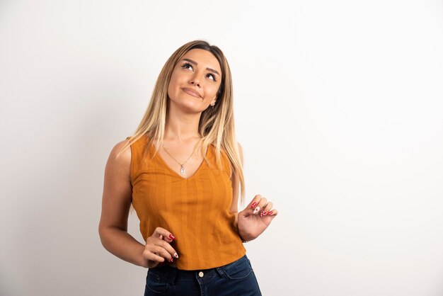 Modelo de mujer joven en ropa casual posando sobre fondo blanco.