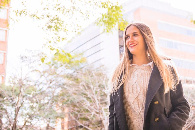 Modelo de mujer joven sonriendo en edificio urbano fondo brillante