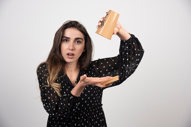 Modelo de mujer joven sosteniendo una taza de café vacía