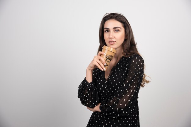 Modelo de mujer joven sosteniendo una taza de café