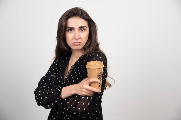 Modelo de mujer joven sosteniendo una taza de café