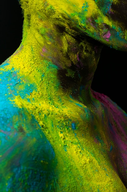 Modelo negro posando con polvo de colores de cerca