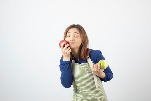 Foto gratuita un modelo de niña linda en delantal con manzanas.