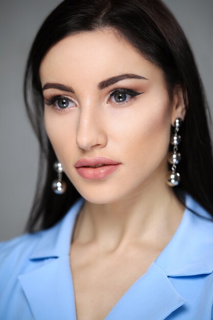 Modelo de ojos azules con chaqueta roja y aretes de diseño