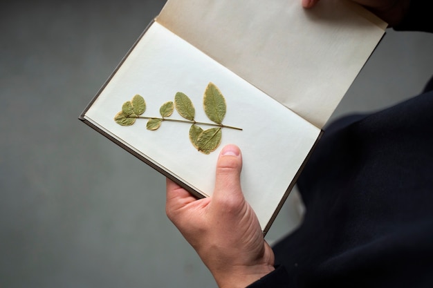 Foto gratuita modelo plano laico sosteniendo libro con flores.