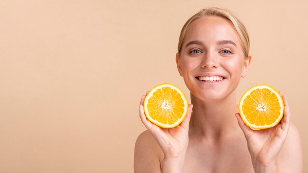 Modelo de primer plano sonriente con naranja y espacio de copia