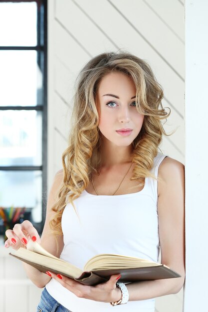 Modelo rubia femenina leyendo un libro