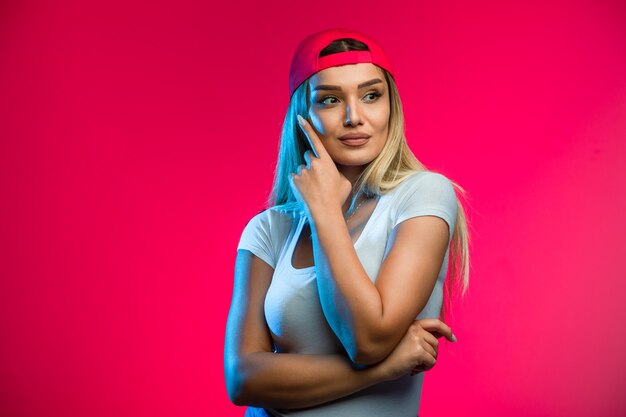 Modelo rubio con gorra roja.