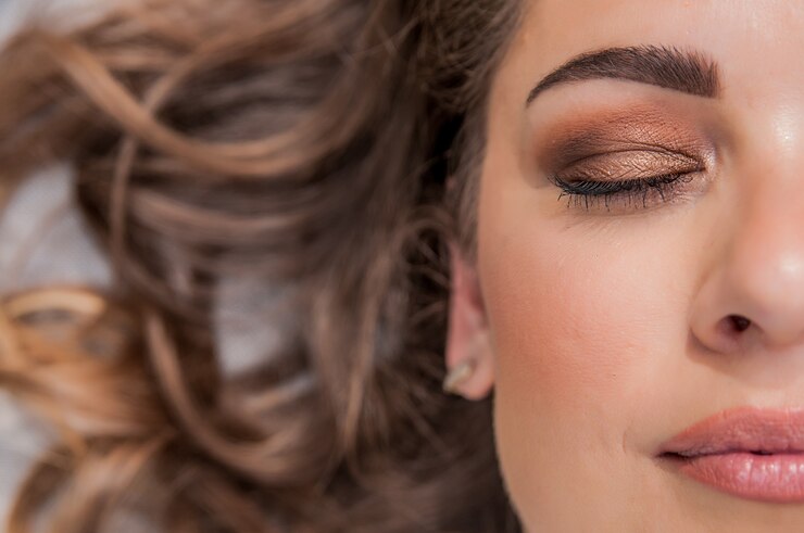 Modelo sensual de la mujer con el pelo azotado por el viento pelo moreno sobre fondo gris claro. Peinado largo brillante de la salud. Belleza y cuidado del cabello. Maquillaje natural de la manera