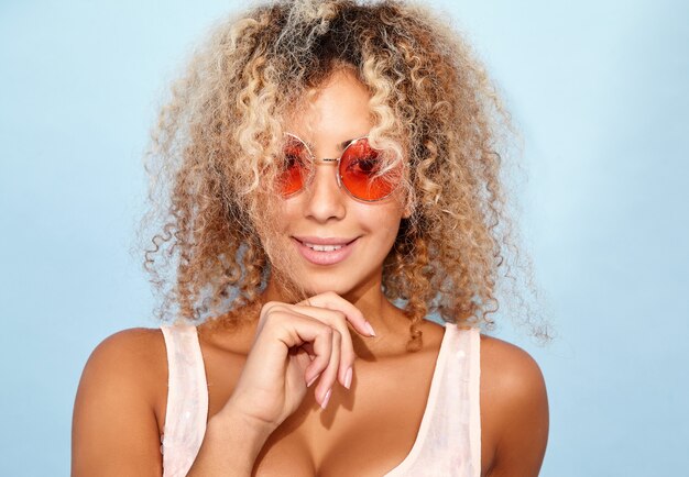 Modelo sonriente en ropa de verano de moda en gafas de sol