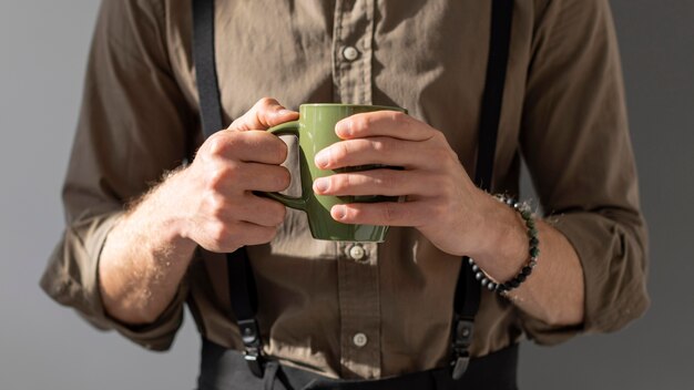 Modelo sosteniendo una taza de café con ambas manos