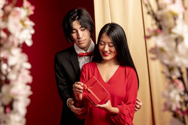 Modelos abrazados con regalo para año nuevo chino