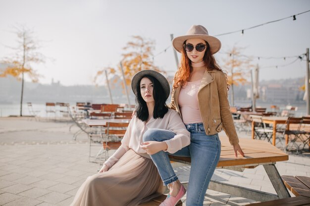 Modelos femeninos blancos disfrutando de un buen día en el parque de otoño