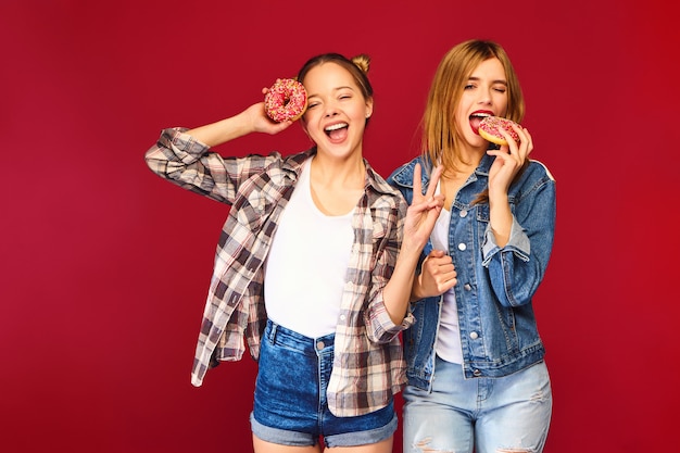 Modelos positivos con rosquillas frescas rosadas en polvo listas para disfrutar dulces