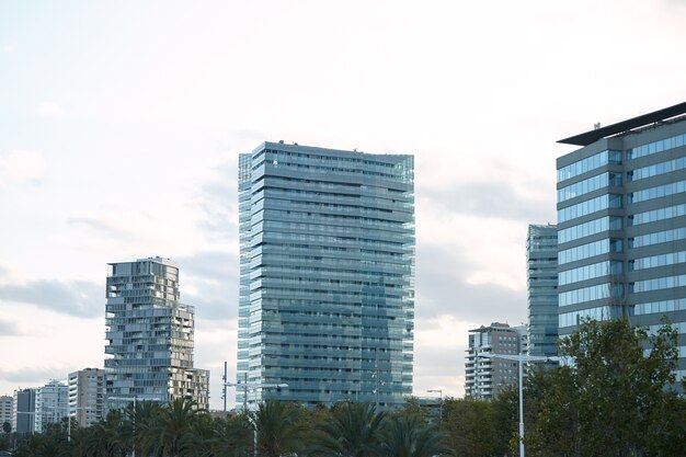 Modernos edificios de cristal y hormigón de la ciudad minutos después del atardecer contra el cielo blanco claro