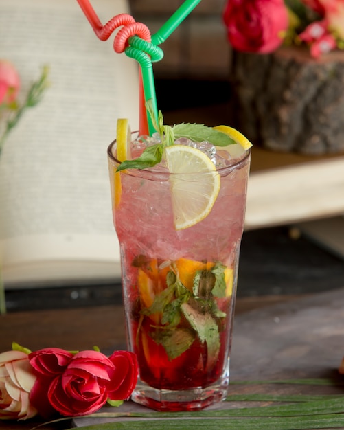 Mojito con jarabe de frutos rojos, lima, menta y cubitos de hielo picados.