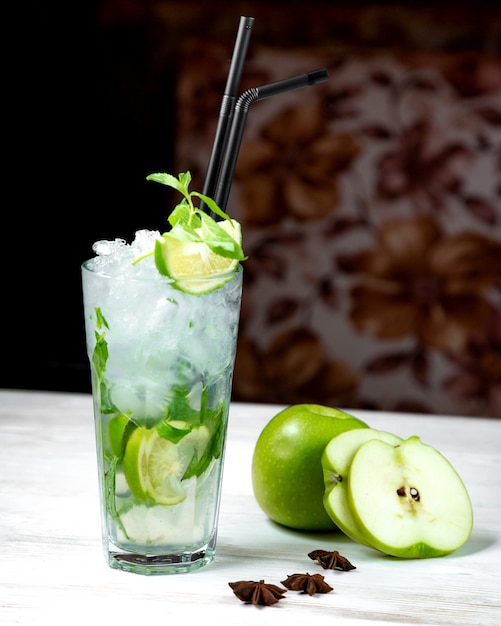 Mojito y rodajas de manzana sobre la mesa