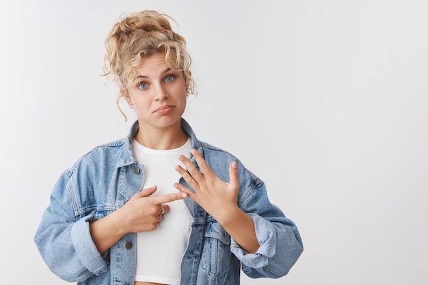 Foto gratuita molesto sombrío bonita escandinava rubia chica de pelo rizado ojos azules frunciendo el ceño sentirse triste infeliz levantar la mano mostrar el dedo anular decepcionado todavía soltero quiero feliz, el sueño convertido en novia recibir propuesta