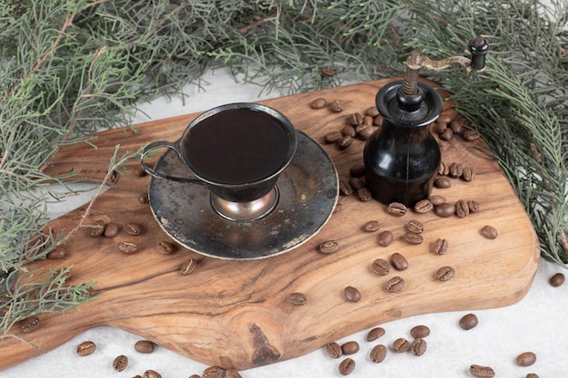 Molinillo de café, frijoles y café aromático en tablero de madera