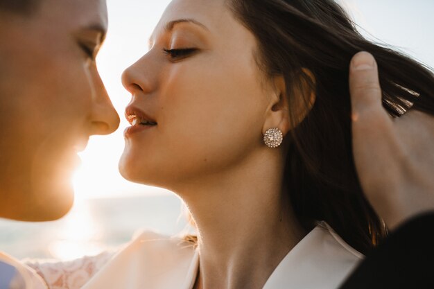 Un momento antes del beso de una joven pareja caucásica hermosa en el día soleado al aire libre