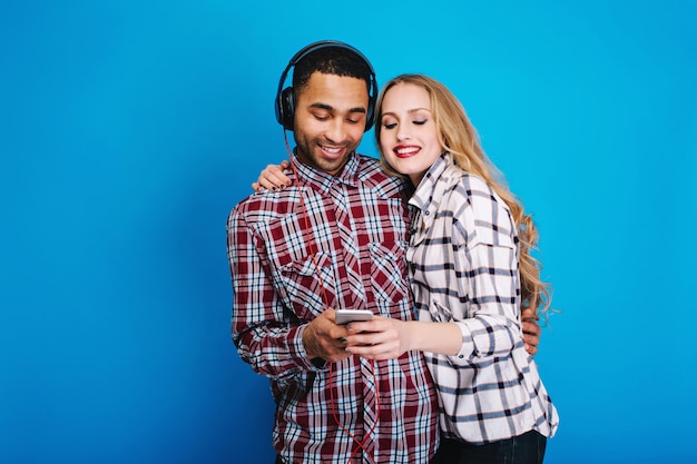 Momentos felices de pareja alegre escuchando música. Divertirse, usar el teléfono, hobby, fines de semana, tiempo libre, disfrutar canciones, expresar positividad, sonreír, amantes.