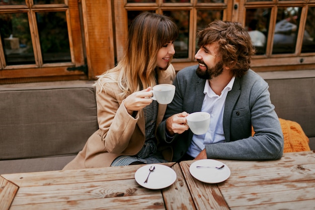 Momentos románticos de una elegante pareja de enamorados sentados en un café, tomando café, conversando y disfrutando del tiempo que pasan juntos.