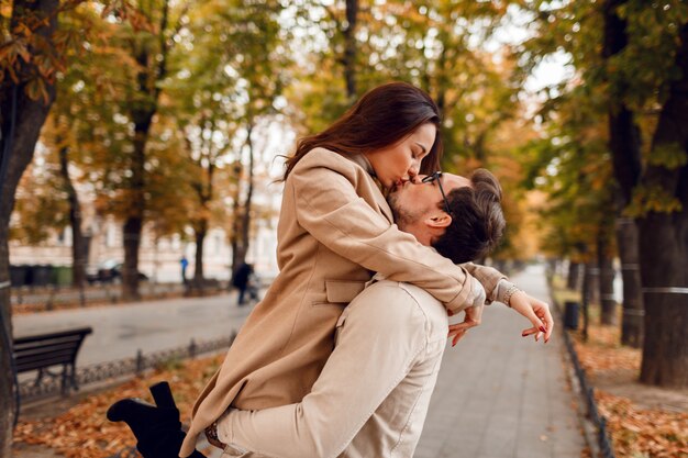 Momentos romanticos. Feliz hermosa pareja de enamorados jugando y divirtiéndose en el increíble parque de otoño.