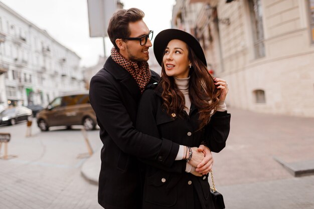 Momentos románticos de hermosa elegante pareja enamorada paseando por la ciudad, abrazándose y disfrutando del tiempo juntos. Colores cálidos. Enamorado