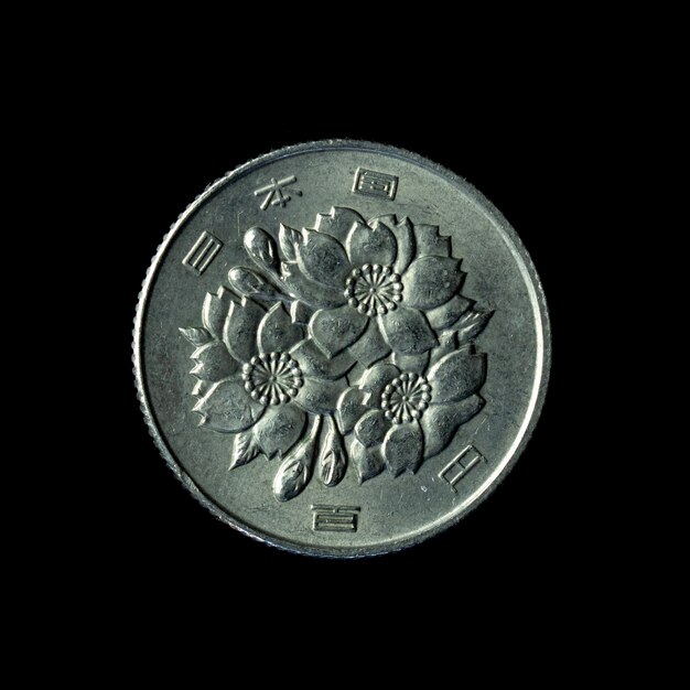 Moneda japonesa de 1967 cien yenes aislada en el fondo negro