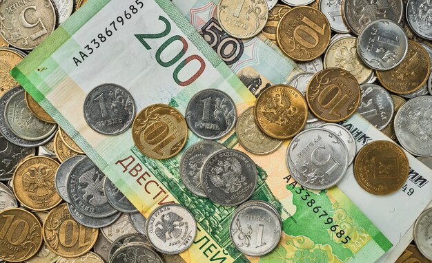 Monedas y billetes de dinero en rublos rusos esparcidos en un montón en la vista superior de la mesa Idea de fondo o banner para noticias de mercado