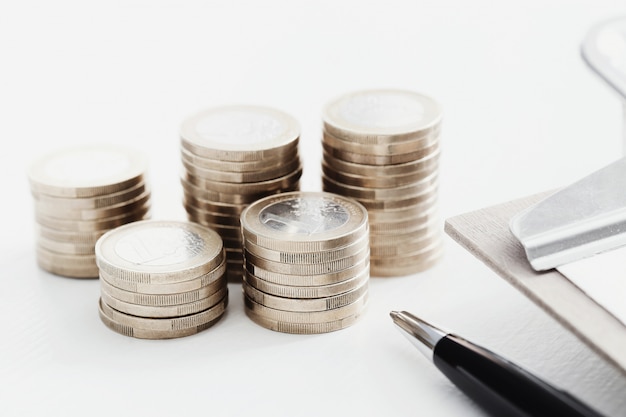 Monedas y bolígrafo sobre mesa de madera